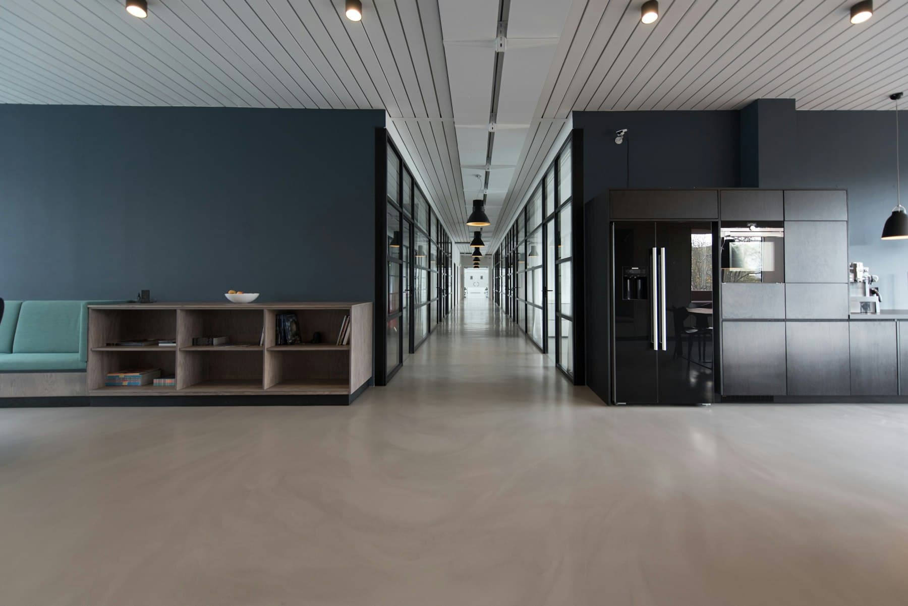 An empty office with long desks and dark monitors
