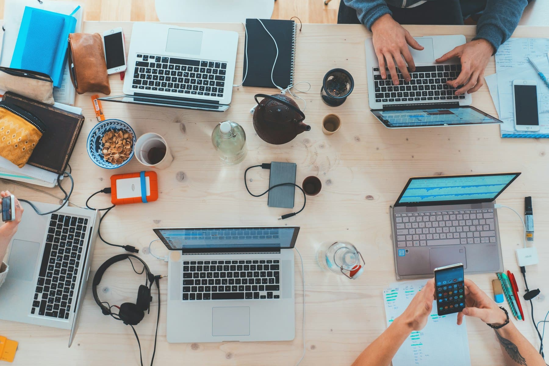 People working at laptops around a long table